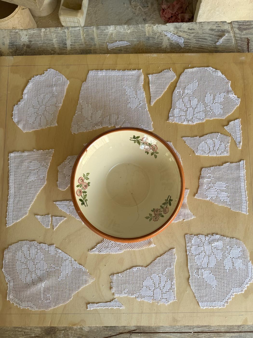 Stone surface with an embroidered doily and an earthenware bowl set into it